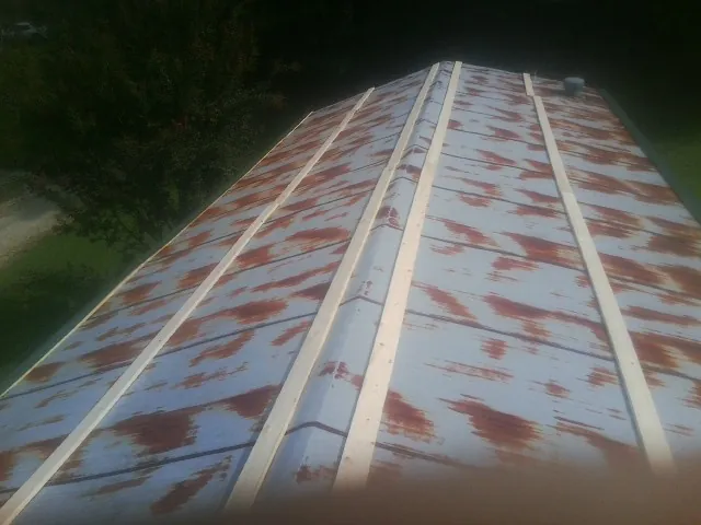 Rusted metal roof panels with new wood purlins before replacement — Storm Damage Roof Repair in Altair by Roofing Brothers